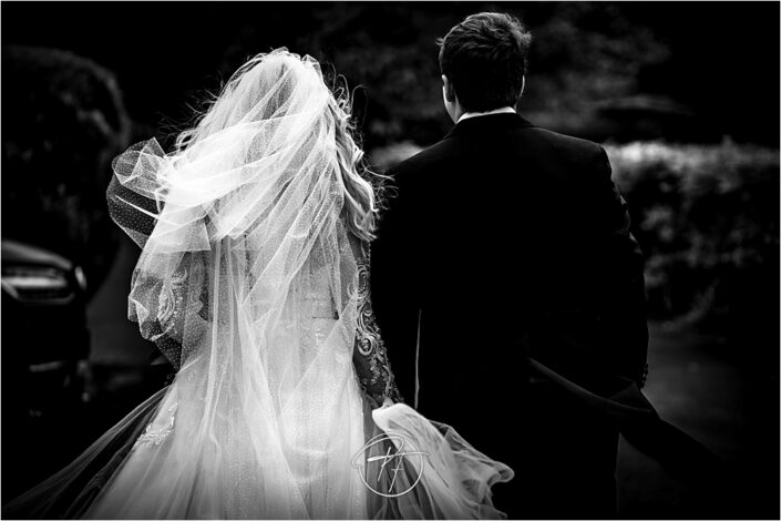 Bride and Groom walking away in the wind