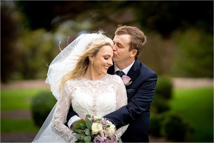 Bride cuddled by Groom