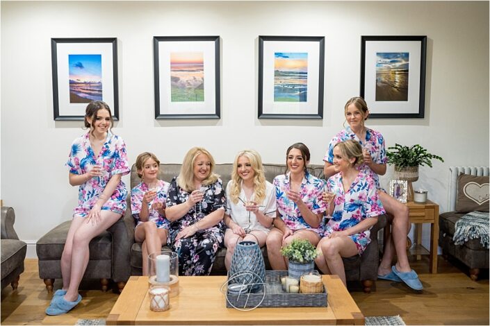 Bridal party in matching dressing gowns having pre drinks before the wedding